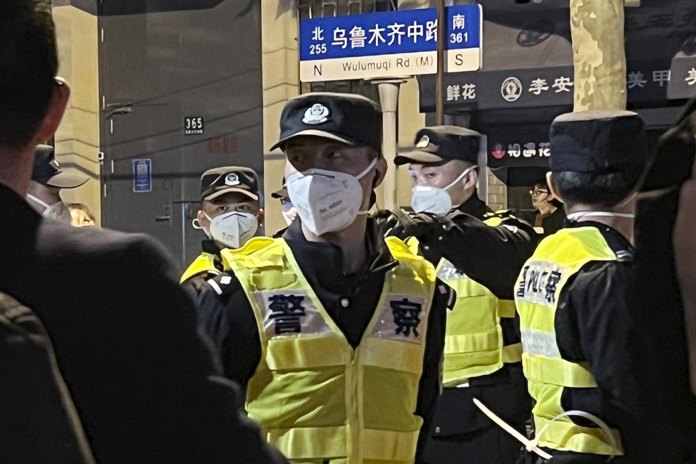 Chinese police officers block off access to a site where protesters had gathered in Shanghai on Sunday, Nov. 27, 2022. Protests against China's strict 