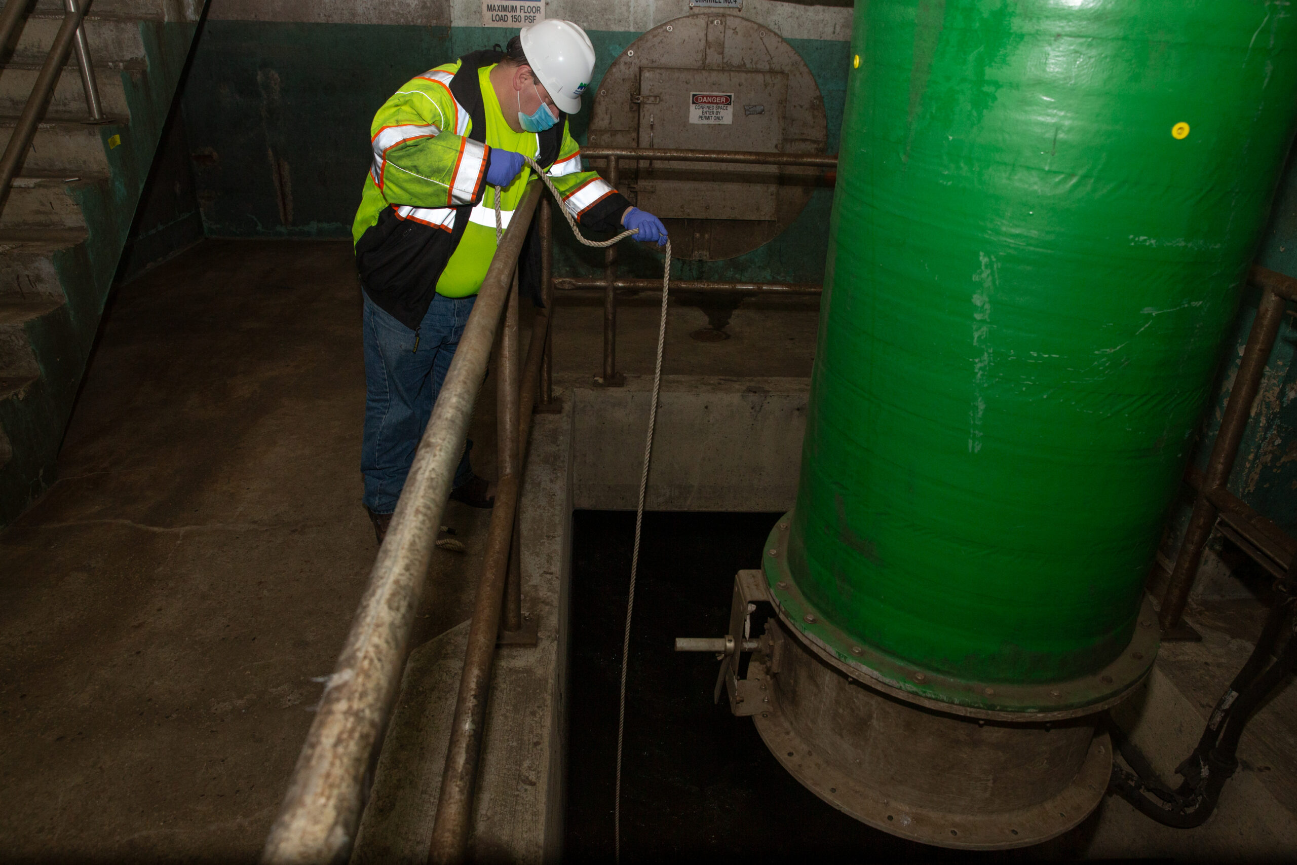 Department of Environmental Protection worker Michael Radano collects a sample from the Newtown Creek Wastewater Treatment Plant for coronavirus sample testing.
