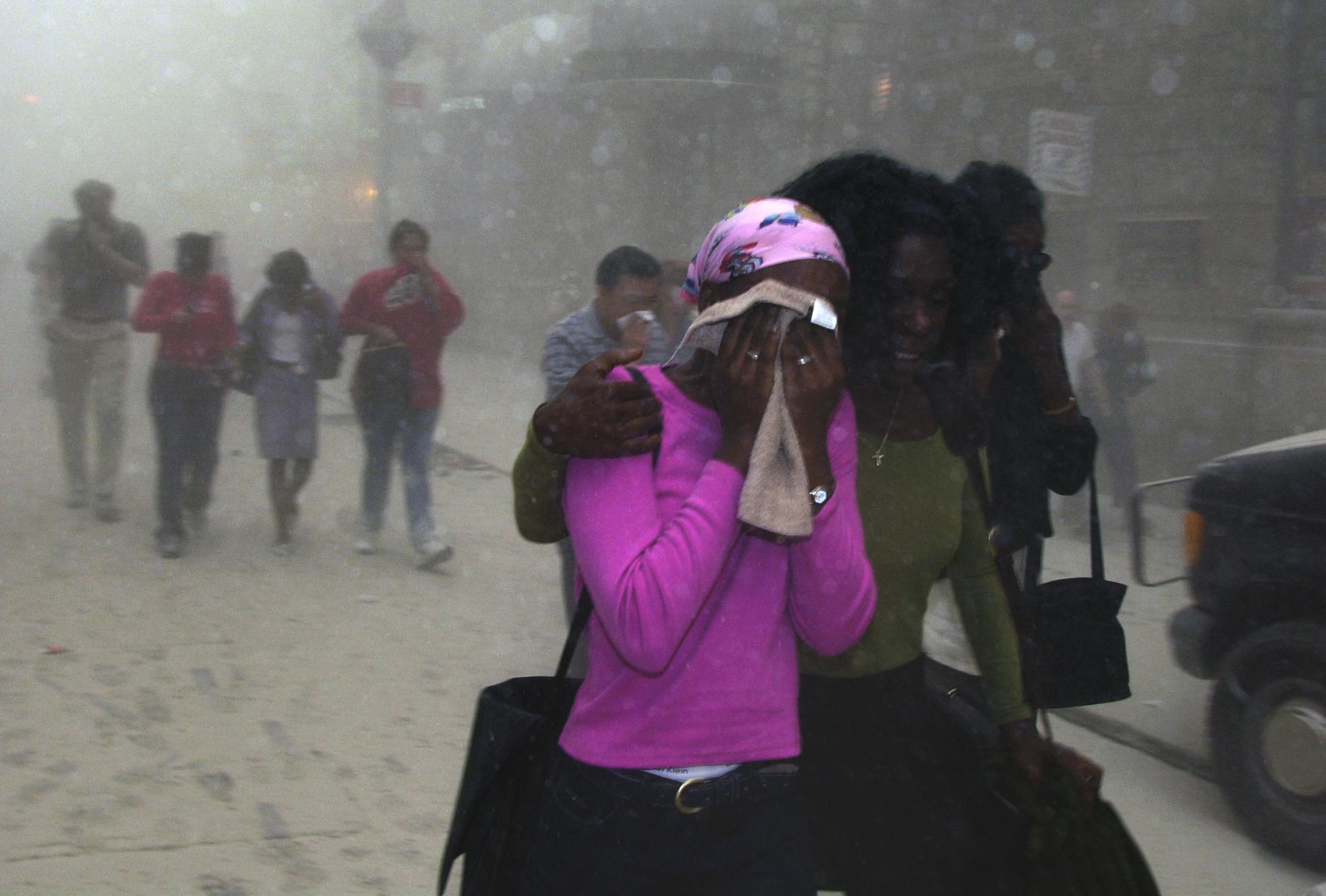 People cover their faces as they escape the collapse of New York's World Trade Center on Sept. 11, 2001. (AP Photo/Suzanne Plunkett)
