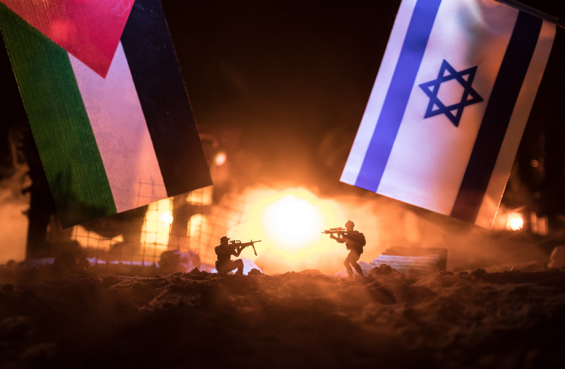  An illustrative image of gunfire to Israeli and Palestinian flags. (credit: SHUTTERSTOCK)