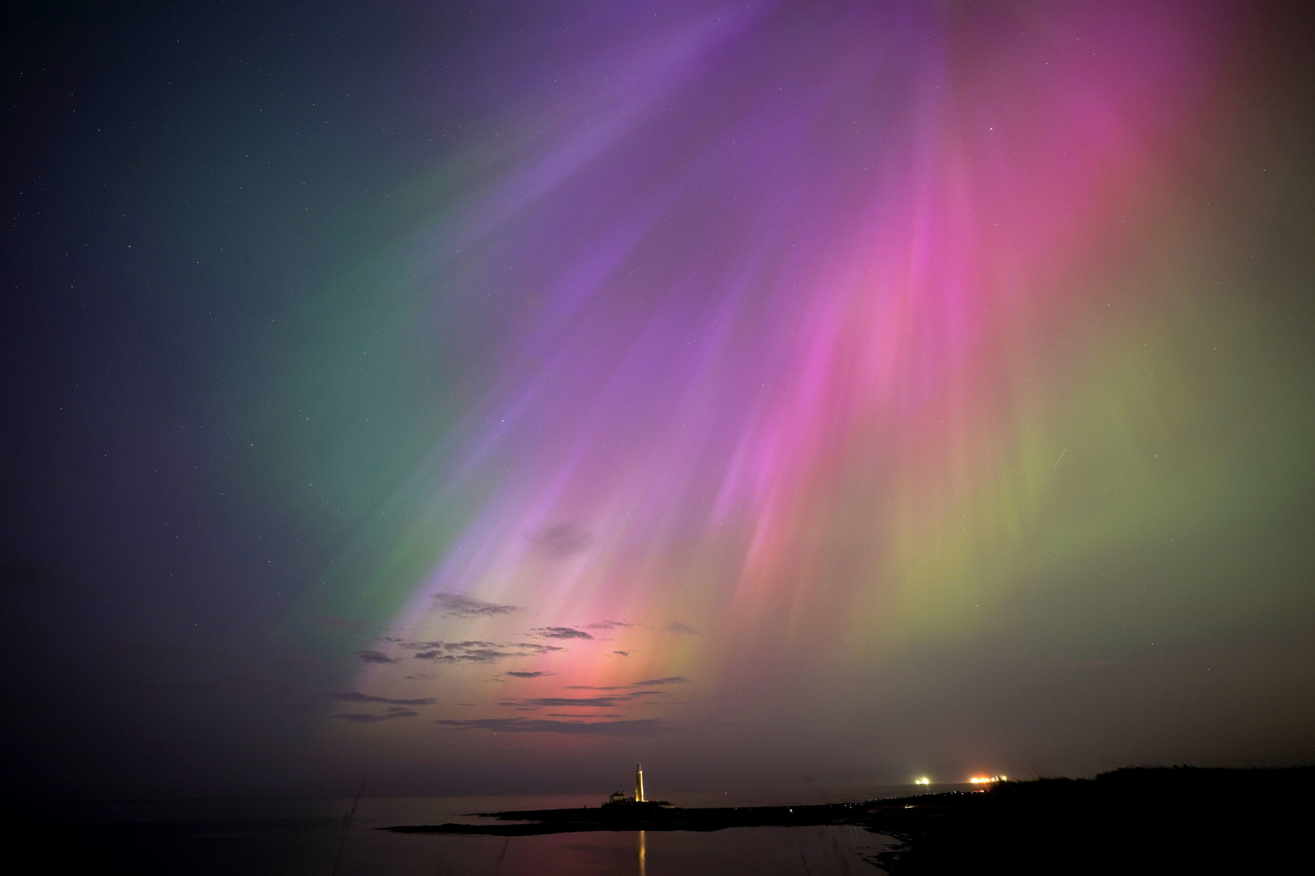 The aurora borealis, also known as the northern lights, glow on the horizon at St. Mary's Lighthouse in Whitley Bay on the North East coast, England, Friday, May 10, 2024. (Owen Humphreys/PA via AP)