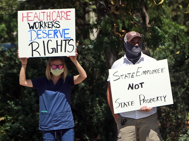 Nurse Katrina Philpot protests against COVID-19 vaccine and mask mandates demonstrate near the state Capitol on Friday, Aug. 20, 2021, in Santa Fe, N.M. Gov. Michelle Lujan Grisham issued a health order this week obligating hospital workers to get COVID-19 vaccines. State workers are also ordered to get vaccinated. Philpot says her Rio Rancho hospital will fire her if she doesn't get her shots. (AP Photo/Cedar Attanasio)