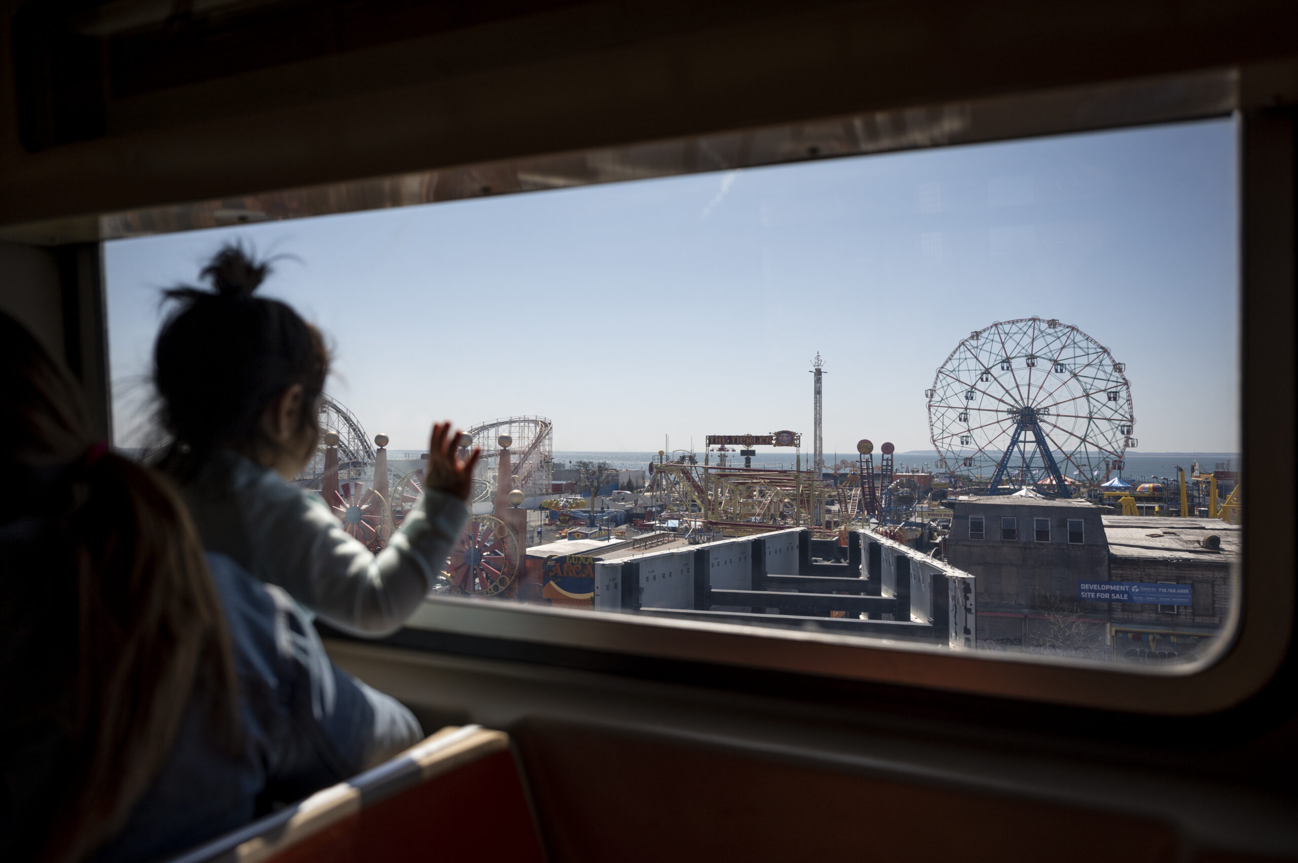 A child marvels at the Wonder Wheel and the rest of Coney Island as the Q train approaches the Stillwell Avenue station.
