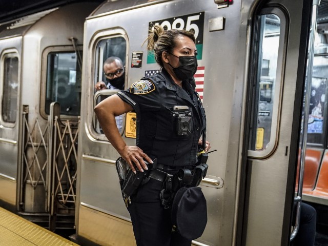FILE - A New York City Police Department officer and a subway conductor look down the subway platform at the Grand Central Terminal subway station, in New York, on May 18, 2021. New York City police arrested 143 people in the city's subways and removed 455 people from from trains and stations in the first week of a crackdown on crime and the presence of homeless people in the transit system