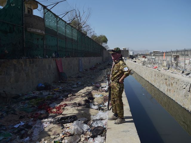 A Taliban fighter stands guard at the site of the August 26 twin suicide bombs, which killed scores of people including 13 US troops, at Kabul airport on August 27, 2021. (Photo by WAKIL KOHSAR / AFP) (Photo by WAKIL KOHSAR/AFP via Getty Images)