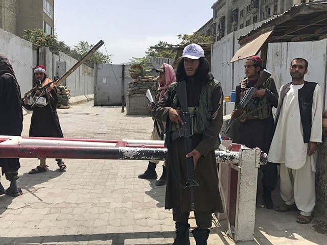 Taliban fighters stand guard at a checkpoint near the US embassy that was previously manned by American troops, in Kabul, Afghanistan, Tuesday, Aug. 17, 2021. The Taliban declared an 
