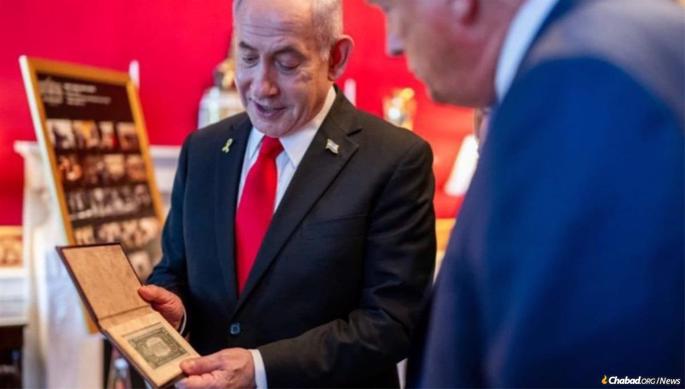 Israeli Prime Minister Benjamin Netanyahu presents U.S. President Donald Trump with a dollar from the Rebbe.
