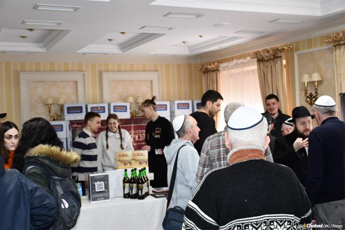 Rabbi Mendel Gottlib talks with his community members in Lviv at the pre-Passover aid distribution. - JNRU