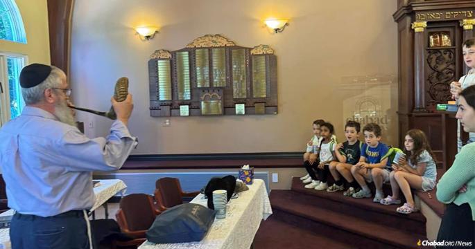 Rabbi Altie Buiket blows the shofar for students at Chabad of Lexington's Hebrew School.