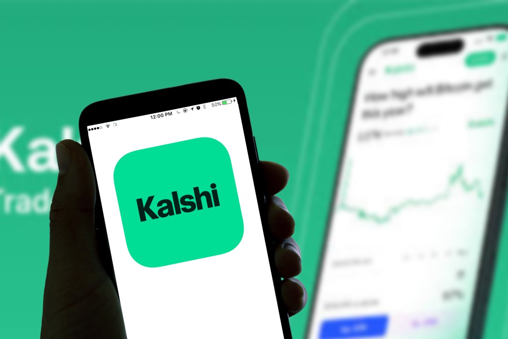 Illustration of a smartphone displaying the Kalshi online betting app logo on its screen.