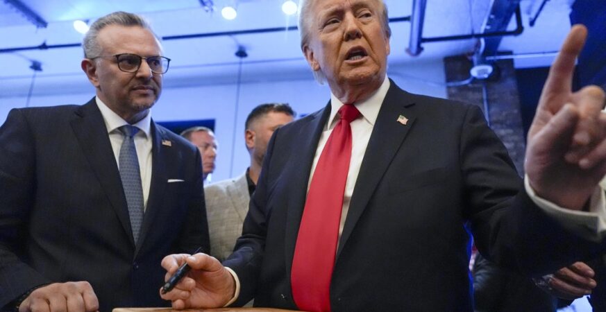 Republican presidential nominee former President Donald Trump signs autographs as Massad Boulos listens during a visit to The Great Commoner, Nov. 1, 2024, in Dearborn, Mich. (AP Photo/Julia Demaree Nikhinson, File)