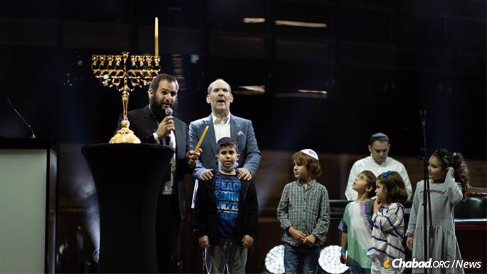 Each night of Hanukkah will feature a holiday concert, where, on the first night, Rabbi Duchman lit a smaller menorah, joined by singer Yishai Lapidot. (Credit: Yehuda Lavi/JCC of the UAE)